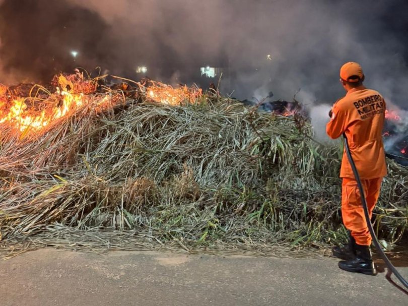 Bombeiros combatem incêndio em resíduos em área de vegetação...